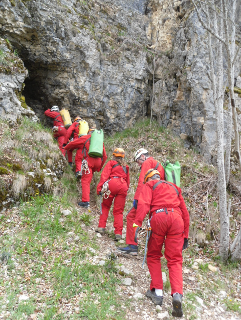 En file d'indienne, devant l'entrée de la grotte